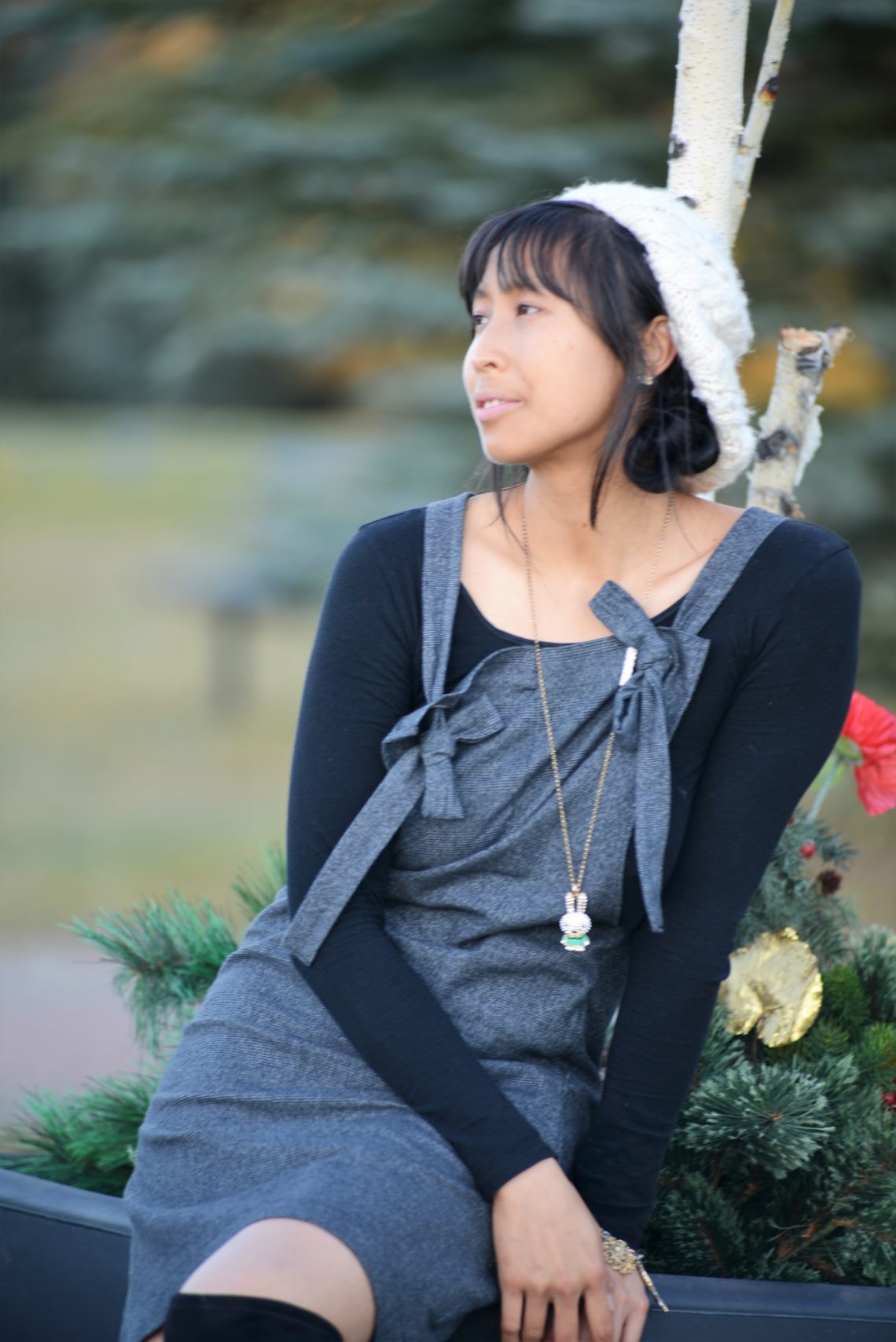 Thanh wearing a refashioned dress from pants, as well as knee high boots, black top and a hat.